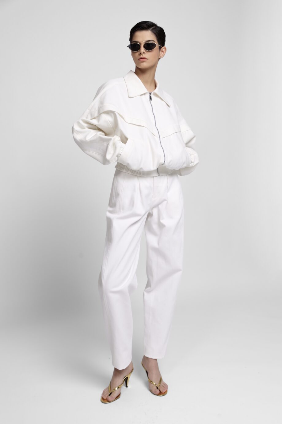 White corduroy two-piece set with cropped jacket and pleated trousers