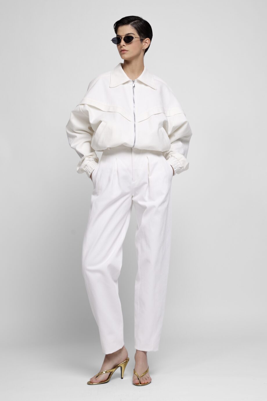 White corduroy two-piece set with cropped jacket and pleated trousers